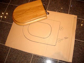 A toilet seat being used to create an outline for the toilet seat template