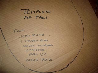 A toilet seat template marked with a name, address and phone number